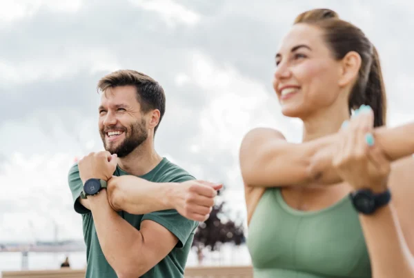 Man and Woman with arms stretching outdoors