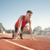 Track athlete ready to sprint, highlighting peak performance preparation