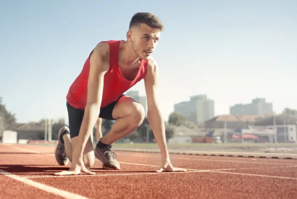 Track athlete ready to sprint, highlighting peak performance preparation
