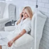 Smiling woman talking on the phone while receiving an IV treatment in a lounge.