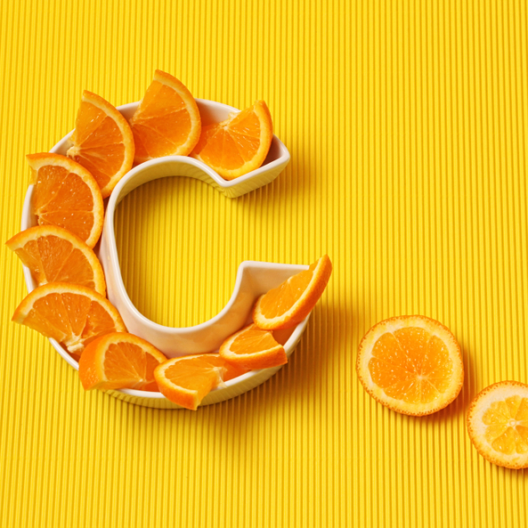 Fresh oranges arranged in the shape of the letter C, representing Vitamin C IV infusion therapy.